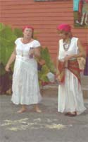 Heat and humidity rise visibly steaming from the pavement on Piety Street where Voodoo priestess Manbo Sallie Ann Glassman calls out her neighbors in the Bywater district to pray once again for nature's mercy. 